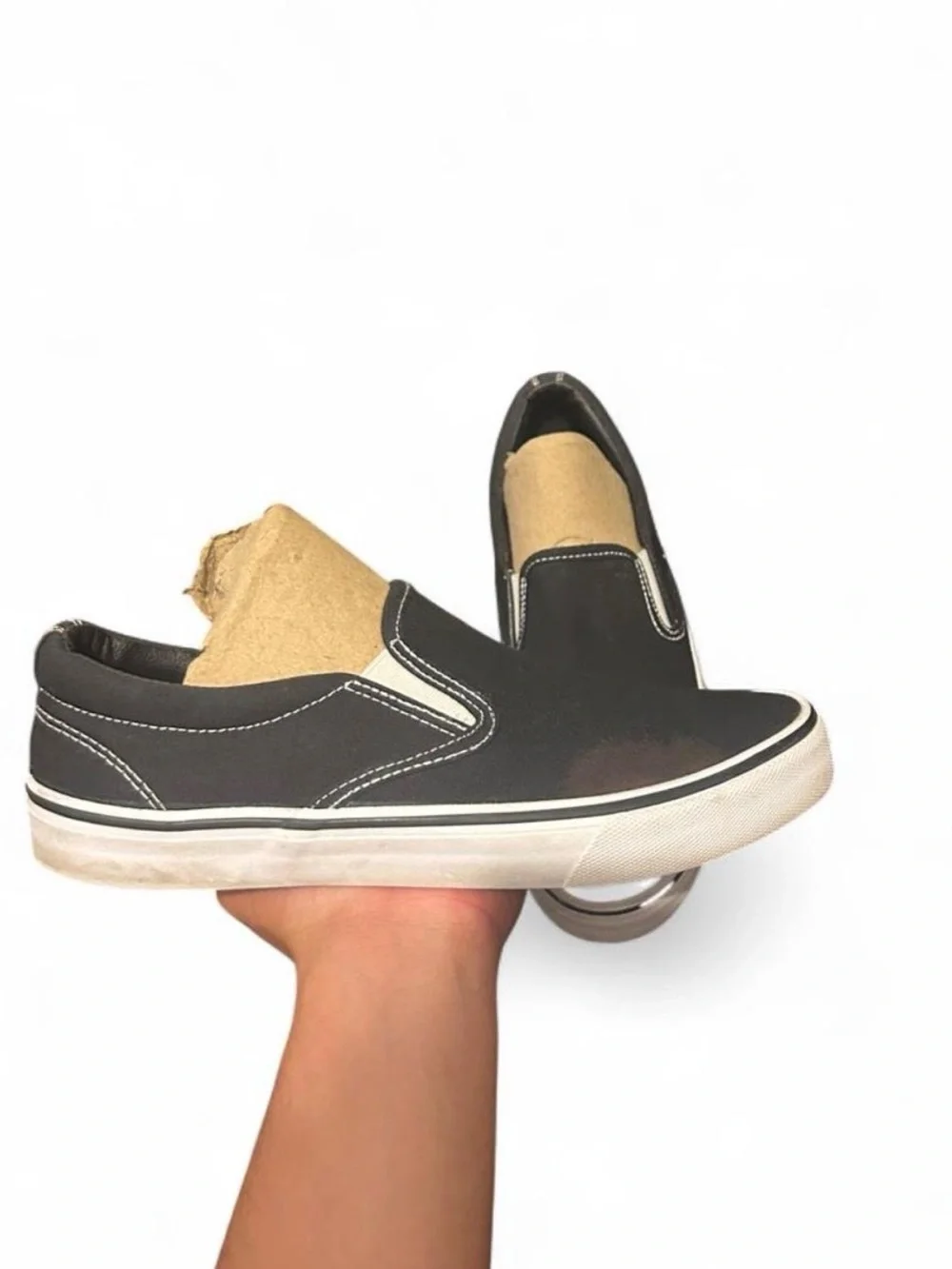 Black slip-on sneakers with white sole and white stitching